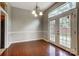 Dining area with hardwood floors, white wainscoting, chandelier, and double doors leading to the yard at 13417 Krislyn Woods Pl, Charlotte, NC 28278