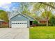 Charming single-story home with a blue exterior, well-manicured lawn, and attached two car garage at 13417 Krislyn Woods Pl, Charlotte, NC 28278