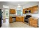 Modern kitchen with stainless steel appliances, tile flooring, and wooden cabinets and view to the yard at 13417 Krislyn Woods Pl, Charlotte, NC 28278