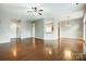 Spacious living area with hardwood floors, ceiling fan, and view into foyer and dining room at 13417 Krislyn Woods Pl, Charlotte, NC 28278