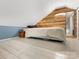Attic space with bed and wood paneled accent wall and painted floor at 1395 Roundstone Rd, Sherrills Ford, NC 28673