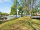 Expansive backyard with lush green grass and mature trees overlooking a serene lake with private dock at 1395 Roundstone Rd, Sherrills Ford, NC 28673