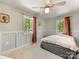 Bright bedroom with neutral walls, paneled accent wall, and views of trees outside at 1395 Roundstone Rd, Sherrills Ford, NC 28673