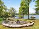 Scenic view of a stone firepit in the backyard leading to a lake with a boat dock at 1395 Roundstone Rd, Sherrills Ford, NC 28673