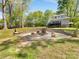 Backyard featuring a custom stone firepit, perfect for outdoor gatherings, with home exterior in the background at 1395 Roundstone Rd, Sherrills Ford, NC 28673