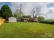 A well-maintained lawn surrounds a brick house with mature trees and a backyard shed at 1663 Smyre Farm Rd # 5, Newton, NC 28658