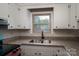 Kitchen featuring white cabinets, granite countertops, and a stainless steel sink under a window at 1663 Smyre Farm Rd # 5, Newton, NC 28658
