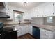 Well-lit kitchen with white cabinetry, granite countertops, and a black range at 1663 Smyre Farm Rd # 5, Newton, NC 28658