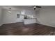 Open-concept living room featuring wood floors, neutral walls, and an adjacent kitchen area at 1663 Smyre Farm Rd # 5, Newton, NC 28658
