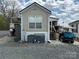 View of home's exterior showcasing air conditioner, boat and golf cart parked in gravel yard at 171 Grand View Dr, New London, NC 28127