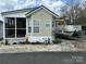 Quaint manufactured home featuring neutral siding, awning windows, and adjacent boat with trailer at 171 Grand View Dr, New London, NC 28127