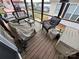 Cozy sunroom features wicker furniture, a glass table, and views of the surrounding landscape at 171 Grand View Dr, New London, NC 28127
