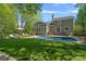 Inviting backyard with in-ground pool, green lawn, sunroom, and lounge furniture, perfect for outdoor relaxation at 181 Glynwater Dr, Mooresville, NC 28117