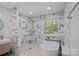 Bathroom featuring luxurious tub, spacious shower with marble surround, and modern fixtures at 181 Glynwater Dr, Mooresville, NC 28117