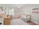 Bright Bedroom features a wood crib, chandelier, charming decor, and accents in a room with wood floor at 181 Glynwater Dr, Mooresville, NC 28117