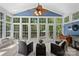 Bright sunroom with large windows, blue accent, tiled floor, comfortable seating, and backyard access at 181 Glynwater Dr, Mooresville, NC 28117