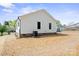 Rear view of a white home with brick foundation and compact air conditioning unit at 203 E 27Th St, Kannapolis, NC 28083