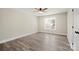 This bedroom features neutral walls, wood-look flooring, a ceiling fan, and a window with a view at 203 E 27Th St, Kannapolis, NC 28083