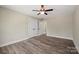 Neutral bedroom with wood-look flooring, a ceiling fan, and double-door closet at 203 E 27Th St, Kannapolis, NC 28083
