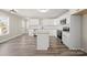 Open concept kitchen with white cabinets, an island, and wood-look flooring at 203 E 27Th St, Kannapolis, NC 28083