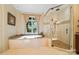 Bright bathroom featuring a garden tub under window and a glass shower at 20428 Island Forest Dr, Cornelius, NC 28031
