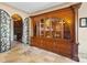 Butler's pantry with wine cellar access, a gorgeous china cabinet, and travertine tile floors at 20428 Island Forest Dr, Cornelius, NC 28031