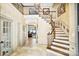 Stunning foyer with travertine floors, winding staircase, wrought iron railings, and views to the lake at 20428 Island Forest Dr, Cornelius, NC 28031