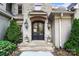 Close up of the double front doors with stone archway, sconces, and meticulously landscaped entryway at 20428 Island Forest Dr, Cornelius, NC 28031