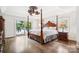 Bright main bedroom featuring a four-poster bed, ceiling fan, and balcony access at 20428 Island Forest Dr, Cornelius, NC 28031