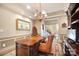 Elegant home office with rich wood desk, chandelier, and view to staircase at 20428 Island Forest Dr, Cornelius, NC 28031