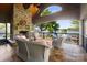 Covered patio featuring stone fireplace, ceiling fan, and beautiful lake views at 20428 Island Forest Dr, Cornelius, NC 28031