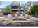 Outdoor patio with a stone firepit, seating, and manicured landscape at 20428 Island Forest Dr, Cornelius, NC 28031