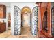 Arched entrance to the wine cellar featuring wrought iron gates, stone floor, and brick ceiling at 20428 Island Forest Dr, Cornelius, NC 28031