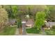 An aerial view of the home with lush landscaping, mature trees, detached garage and long driveway at 2239 Wensley Dr, Charlotte, NC 28210