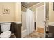 Bathroom features a toilet, a shower/tub with a curtain, and mocha colored panelling at 2239 Wensley Dr, Charlotte, NC 28210