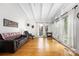 Open-concept living room offers large windows with curtains, hardwood floors, and a cozy leather sofa at 2239 Wensley Dr, Charlotte, NC 28210