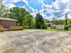 Backyard view of a brick home with a shed and mature trees at 225 Enwood Dr, Charlotte, NC 28214