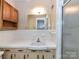 Vintage-style bathroom featuring white tile, oak cabinetry and shower at 225 Enwood Dr, Charlotte, NC 28214
