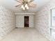 Bedroom with floral wallpaper, carpeted floor, plantation shutters, and ceiling fan with light at 225 Enwood Dr, Charlotte, NC 28214