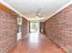 Sunroom with brick walls, tile floors, shelves, and ceiling fan with light at 225 Enwood Dr, Charlotte, NC 28214