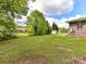 Expansive backyard with lush lawn, mature trees, and a detached garage, perfect for outdoor enjoyment at 225 Enwood Dr, Charlotte, NC 28214