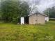 View of a storage shed in a spacious backyard with abundant green grass under a cloudy sky at 229 N Jones Ave, Rock Hill, SC 29730