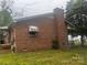 Side view of a red brick house with a brick chimney under a cloudy sky surrounded by a grassy lawn at 229 N Jones Ave, Rock Hill, SC 29730