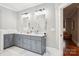 Bathroom featuring double vanity with grey cabinetry, and a separate room with a stand-up shower at 2315 Dundeen St, Charlotte, NC 28216