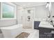 Bright bathroom featuring a soaking tub and glass-enclosed shower with designer tile and updated fixtures at 2315 Dundeen St, Charlotte, NC 28216