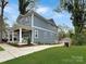 Side view of the home with a green lawn, long driveway, and a detached garage at 2315 Dundeen St, Charlotte, NC 28216