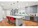 Kitchen with grey cabinets, stainless appliances, large island with seating, and hardwood floors at 2315 Dundeen St, Charlotte, NC 28216