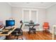 Home office with computer desk, piano, rolling chairs, and hardwood floors at 2315 Dundeen St, Charlotte, NC 28216