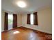 A spacious bedroom with wood floors, and two large windows with dark curtains at 2326 Armstrong Cir, Gastonia, NC 28054