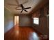 A bright bedroom with wood floors, wood paneled walls, and decorative curtains at 2326 Armstrong Cir, Gastonia, NC 28054